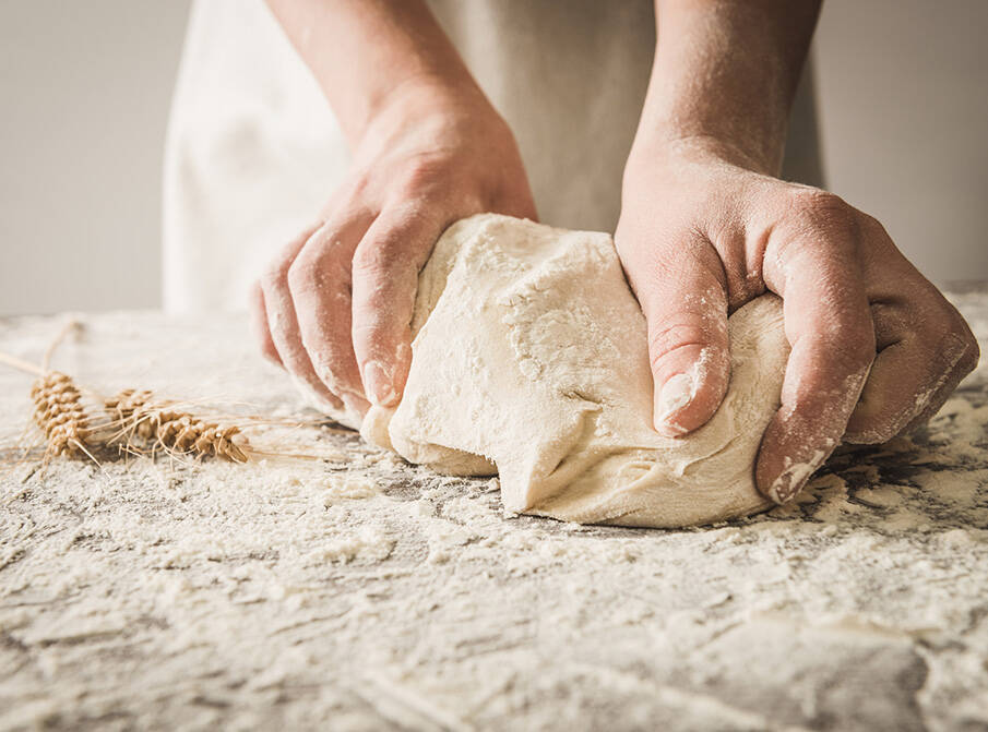 Un boulanger pétrit une pâte